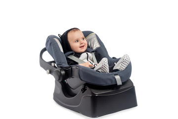 Smiling infant baby child sitting in a car seat, isolated on white