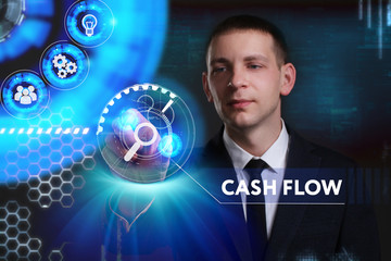 Business, Technology, Internet and network concept. Young businessman working on a virtual screen of the future and sees the inscription: Cash flow