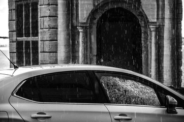 Car in front of cathedral arch in the rain