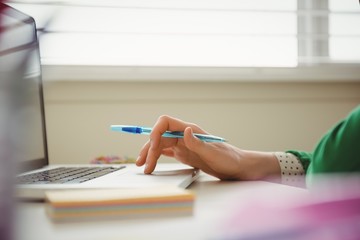 Close up of woman working on laptop at table