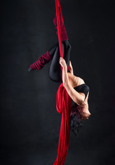 The woman is engaged in aerial acrobatics.
