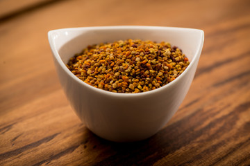 Bee Pollen in a bowl on a wooden surface