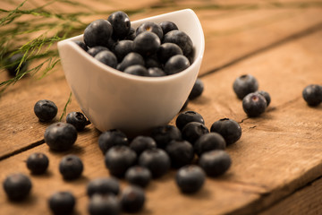 Blueberries in a bowl on wooden surface