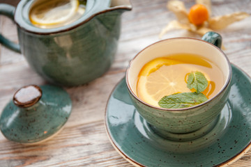 White Cup of Tea with Lemon and Mint on Wooden Table Background. Top View.