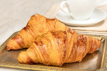 Fresh croissants on vintage tray, with copyspace