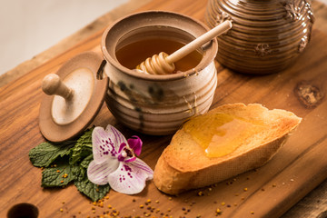 Liquid Honey in Pot with Toast and Honey Stick