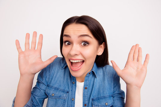 Closeup portrait of surprised smiling girl with open mouth and hands on white background