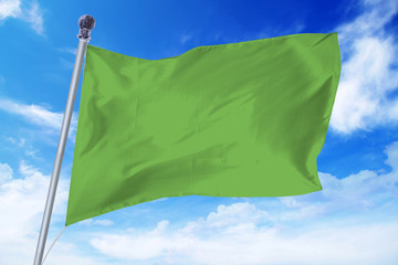 Flag of Libya developing against a clear blue sky
