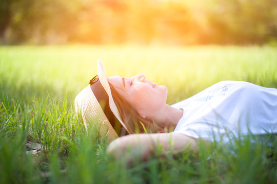 Carefree happy woman lying on green grass meadow,Freedom.Enjoyment.Relaxing on meadow