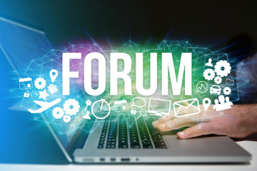Concept of man holding futuristic interface with forum title and multimedia icons flying all around - Internet concept