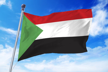 Fototapeta na wymiar Flag of Soudan developing against a clear blue sky