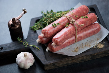Close-up of fresh uncooked sausages made of marbled beef meat, studio shot