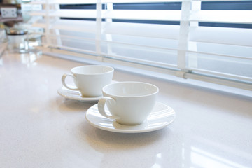 coffee cup beside windows