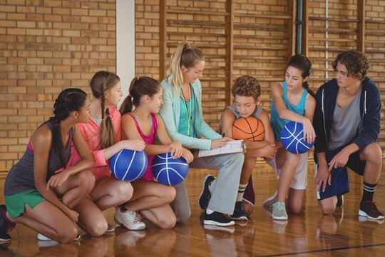 Female coach mentoring high school kids