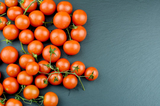 Tomaten - Cocktailtomaten auf einer Schieferplatte mit Textfreiraum