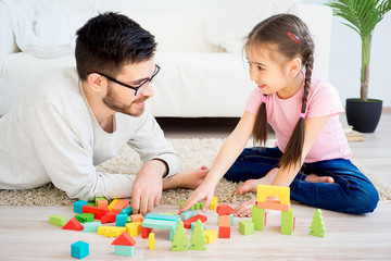Naklejka premium Family playing with toy blocks