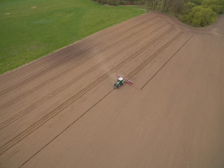 tractor - aerial view of a tractor at work cultivating a field in spring