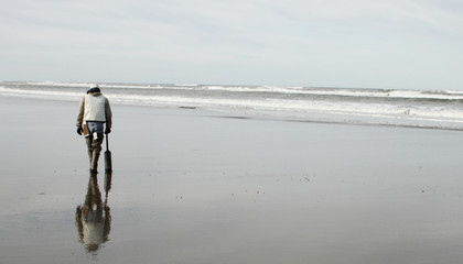 Man hunting for razor clams on the beach.
