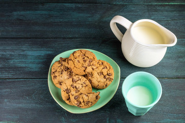 Chocolate chips cookies with glass and jar of milk