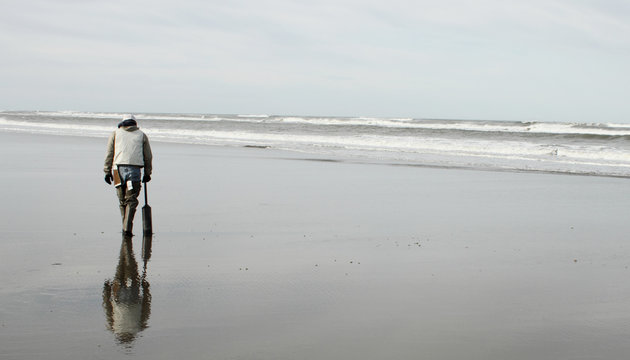 Man Hunting For Razor Clams On The Beach.