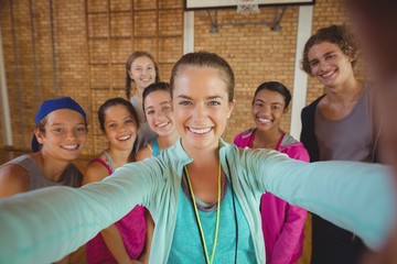 Female coach and high school kids taking a selfie - Powered by Adobe