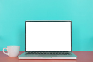 Modern laptop with blank screen, coffee cup on pastel color background.