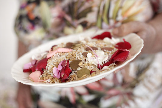 piatto da rompere in segno di buon augurio per gli sposi con dentro monete, riso, petali colorati e grano