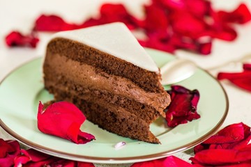 Fototapeta na wymiar Chocolate cake with marzipan, red rose leaf
