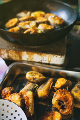 Frying hake fish slices in pan outdoors on picnic