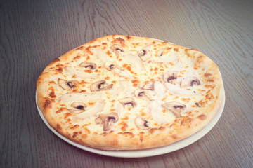 Pizza with mushrooms on wood table