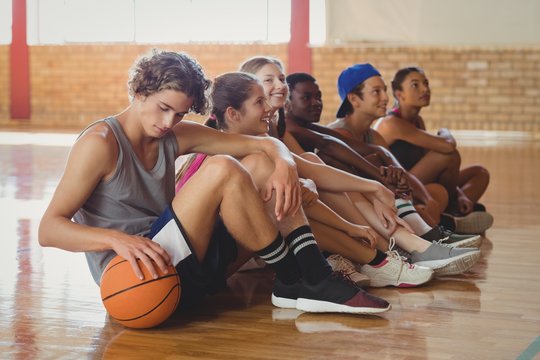 High School Kids Sitting On The Floor In Basketball Court