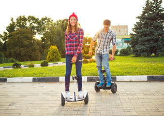 Young couple riding hoverboard - electric scooter, personal eco transport, gyro scooter, smart balance wheel