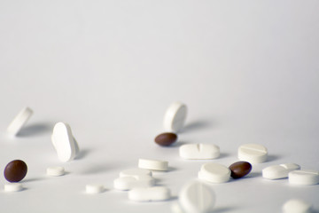 Falling pills on white background