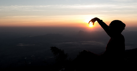 Fototapeta premium Man playing with the sun with silhouette background