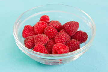 Fresh red raspberries in a glass bowl