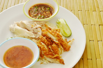 crispy deep fried and boiled chicken on cooked rice dressing different sauce on plate