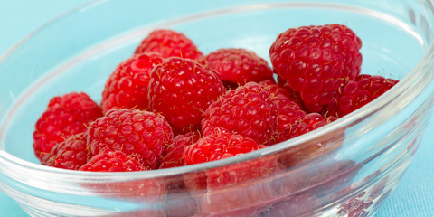 Fresh red raspberries in a glass bowl