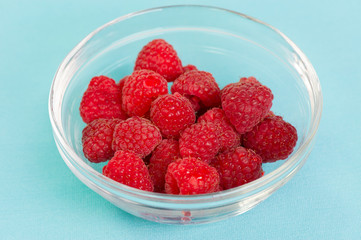 Fresh red raspberries in a glass bowl