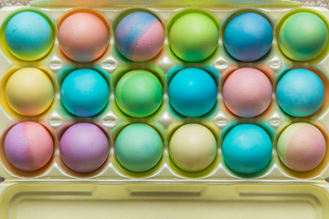 Colorful dyed hard boiled Easter eggs in a foam carton