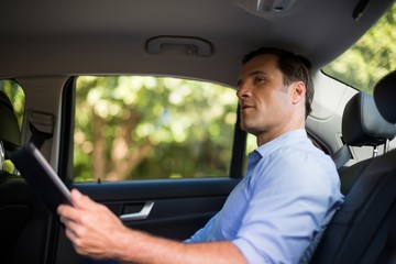 Man holding digital tablet in car