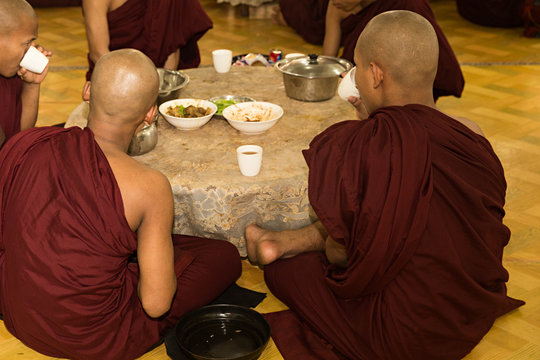 Monjes budistas comiendo en el comedor del monasterio en Myanmar.