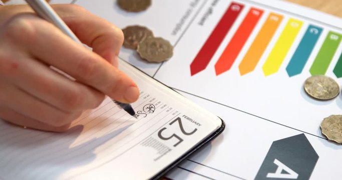 Businesswoman writing on diary at desk in office