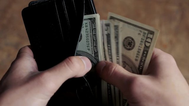 Man counting money in wallet