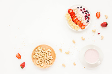 Healthy breakfast. Strawberry yogurt, fresh berry, banana, cereal, muesli, cranberry, blueberries, strawberry, nuts on white background. Top view, flat lay