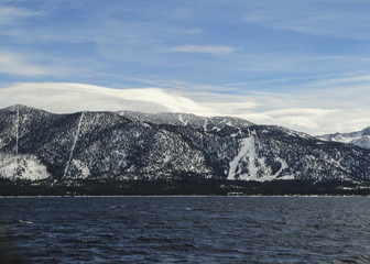 Snow covered mountains with ski slopes as seen from the water
