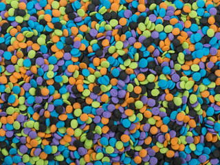 Fototapeta na wymiar Halloween colored candy sprinkles background texture