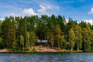 Fototapeta na wymiar Wooden log cabin at the lake in summer in Finland