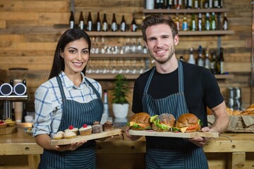 Waiter and waitresses holding cupcakes and food