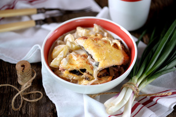 Chicken breast stuffed with mushrooms baked with potatoes under cheese.