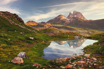 Dawn of a beautiful landscape with the Midi d'Ossau reflecting in a puddle, Huesca, Spain.